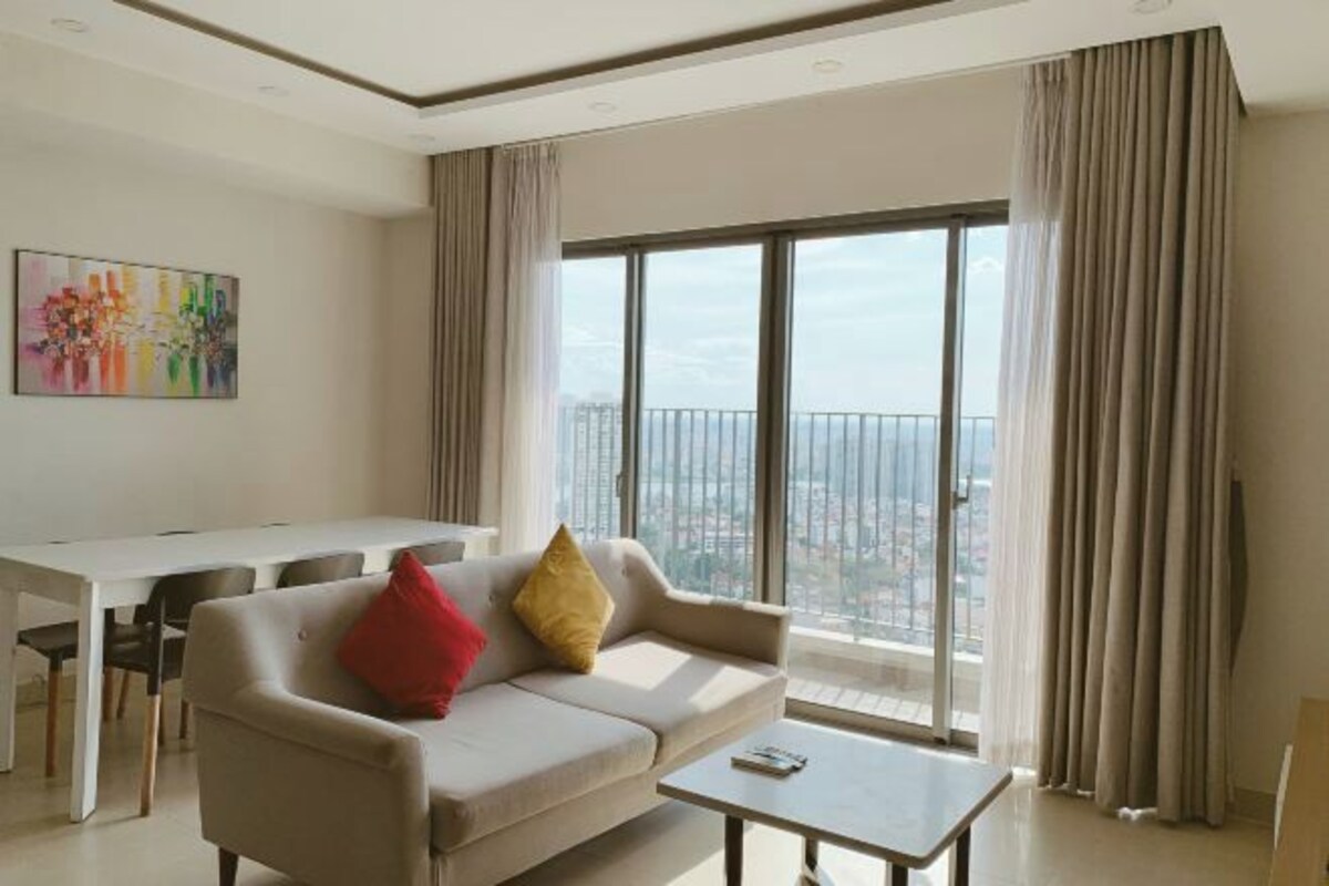 A modern living room with a sofa, a coffee table, and a dining area.