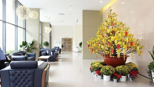 A modern lobby with a large potted plant, seating area, and a door in the background. - Thao Dien Masteri Riverside - Saigon Home (Ho Chi Minh City)