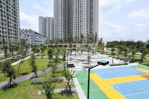 A residential area with high-rise buildings, a sports court, and a landscaped park. - Thao Dien Masteri Riverside - Saigon Home (Ho Chi Minh City)
