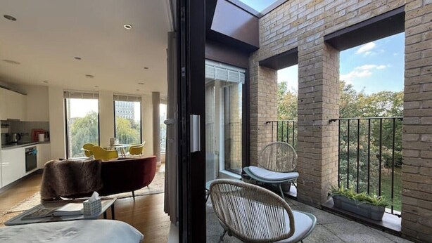 Un appartement moderne doté d’un balcon, d’un coin repas et d’une cuisine.