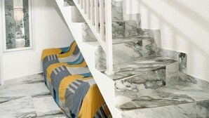 A staircase with white railings and marble steps. - RedDoorz near Politeknik Pariwisata Nusa Dua Bali (Bali)