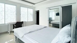 A modern bedroom with a bed, a desk, and a wardrobe. - RedDoorz near Politeknik Pariwisata Nusa Dua Bali (Bali)