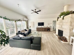 TV connectée, cheminée, livres, chaîne hi-fi