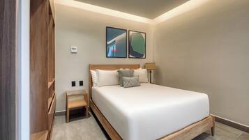 Een moderne slaapkamer met een groot bed, een houten hoofdbord, twee nachtkastjes en twee kunstwerken in een lijst aan de muur.