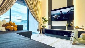 A modern living room with a large window, a flat-screen TV, a sofa, a decorative plant, and a vintage scooter. - Continew Residence by Xuan and Partner (Kuala Lumpur)