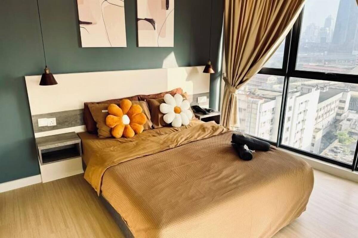 Un dormitorio moderno con una cama grande, vistas a la ciudad y decoración minimalista.