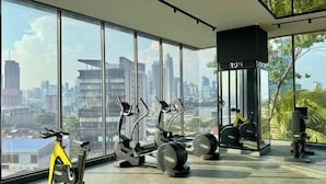 A modern gym with large windows, exercise equipment, and a city view. - Continew Residence by Xuan and Partner (Kuala Lumpur)