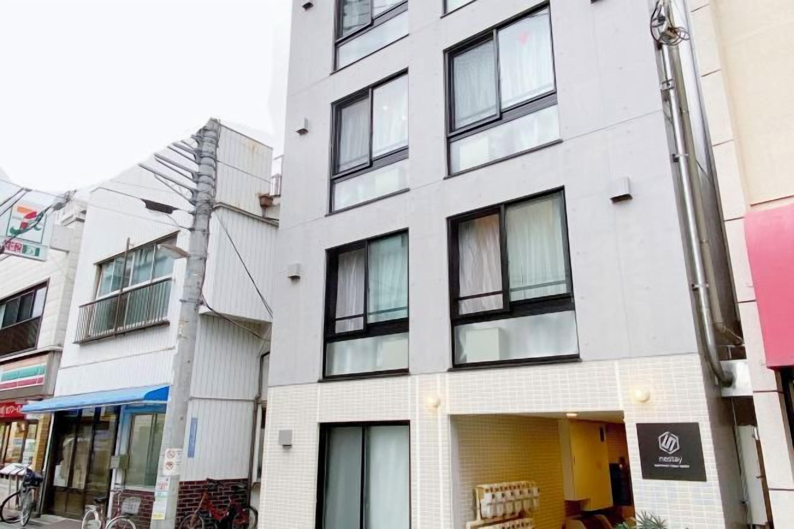 A multi-story building with a modern design, featuring large windows and a visible entrance.