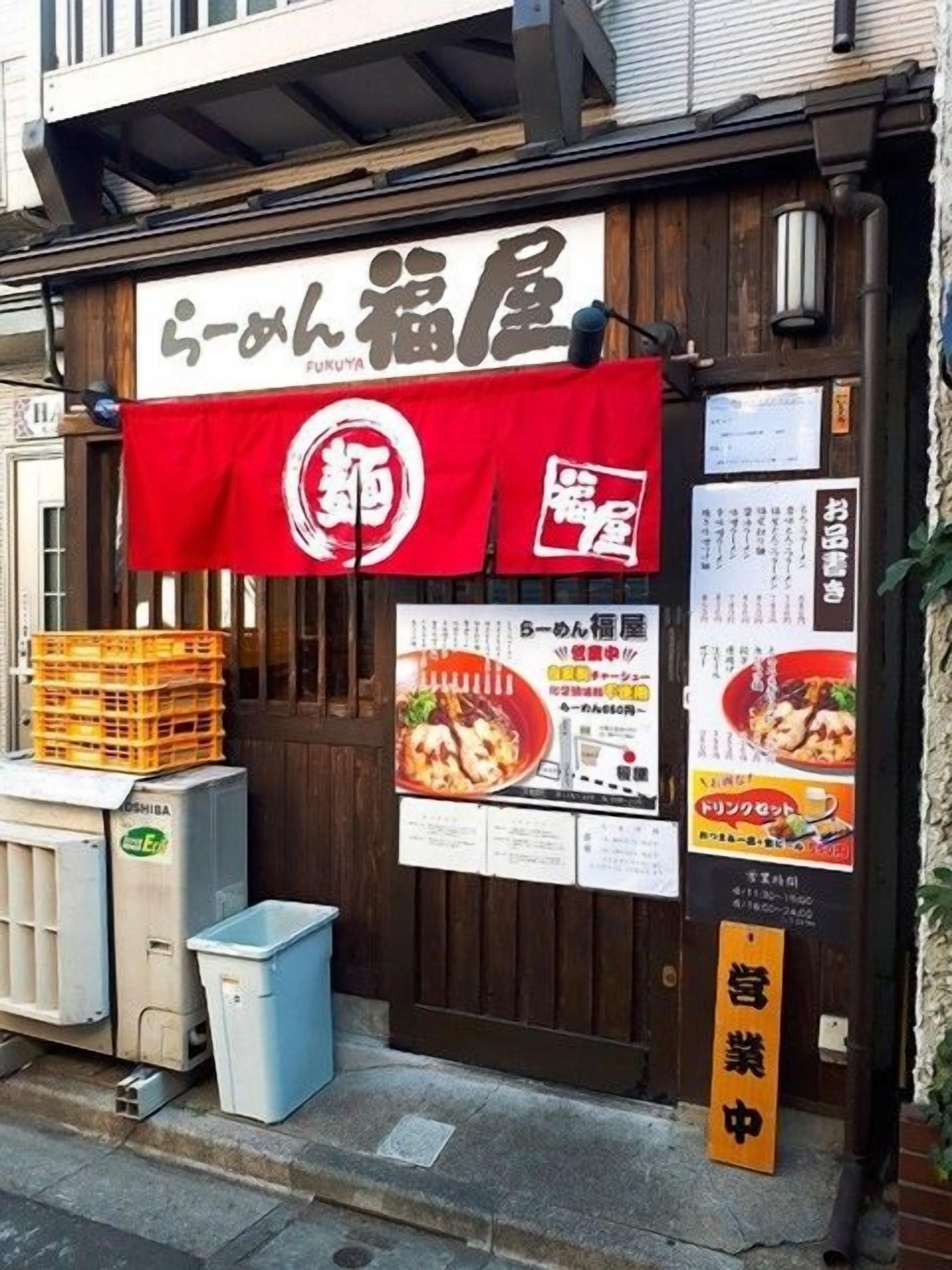 A restaurant with a wooden facade, a red awning, and a menu board.