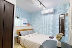 A bedroom with a bed, bedside table, and a small round table with a vase. - Nestay apartment Tokyo Nippori (Tokyo)