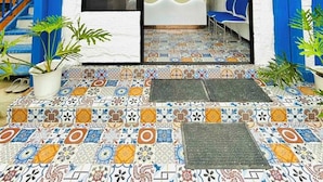 UNA CASA DE HUESPEDES TANDIKAN con una entrada de baldosas coloridas y una zona de recepción.