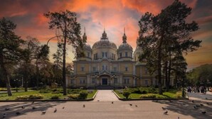 A grand building with multiple domes, surrounded by trees and a pathway leading to the entrance. - HOMESTAY (Almaty)