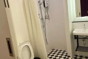 A bathroom with a toilet, a shower, and a sink. - Durian Family Hotel (Bangkok)