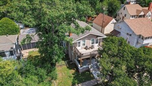 An aerial view of a residential area with houses, a large tree, and a small stream. - The Charming Chestnut (Arkansas City)