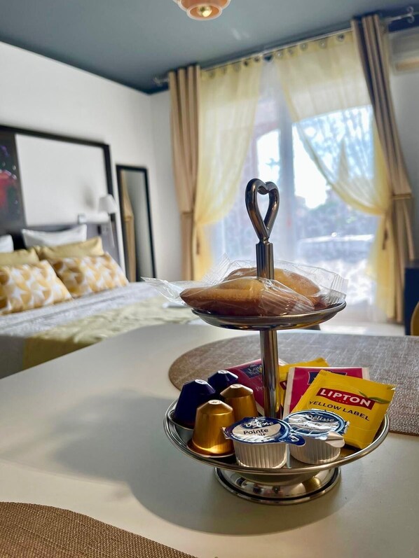 A breakfast tray with pastries, chocolates, and Lipton tea on a hotel table.