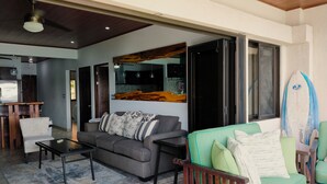 A modern living room with a grey sofa, a green armchair, and a coffee table. - Flamingo Center: 2 BR condo w| gorgeous bay views - Punta Plata 521 (Playa Flamingo)