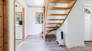 A spacious room with a wooden staircase, a radiator, and a door with a window. - Gorgeous home in Karrebæksminde with WiFi (Karrebæksminde)