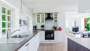 A modern kitchen with white cabinets, a black stove, and a coffee maker. - Gorgeous home in Karrebæksminde with WiFi (Karrebæksminde)