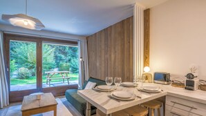 Een moderne keuken met een eethoek, houten lambrisering en uitzicht op het omliggende landschap.