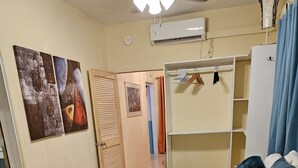 Ein Schlafzimmer mit einem Bett, einem Kleiderschrank und einer Klimaanlage.