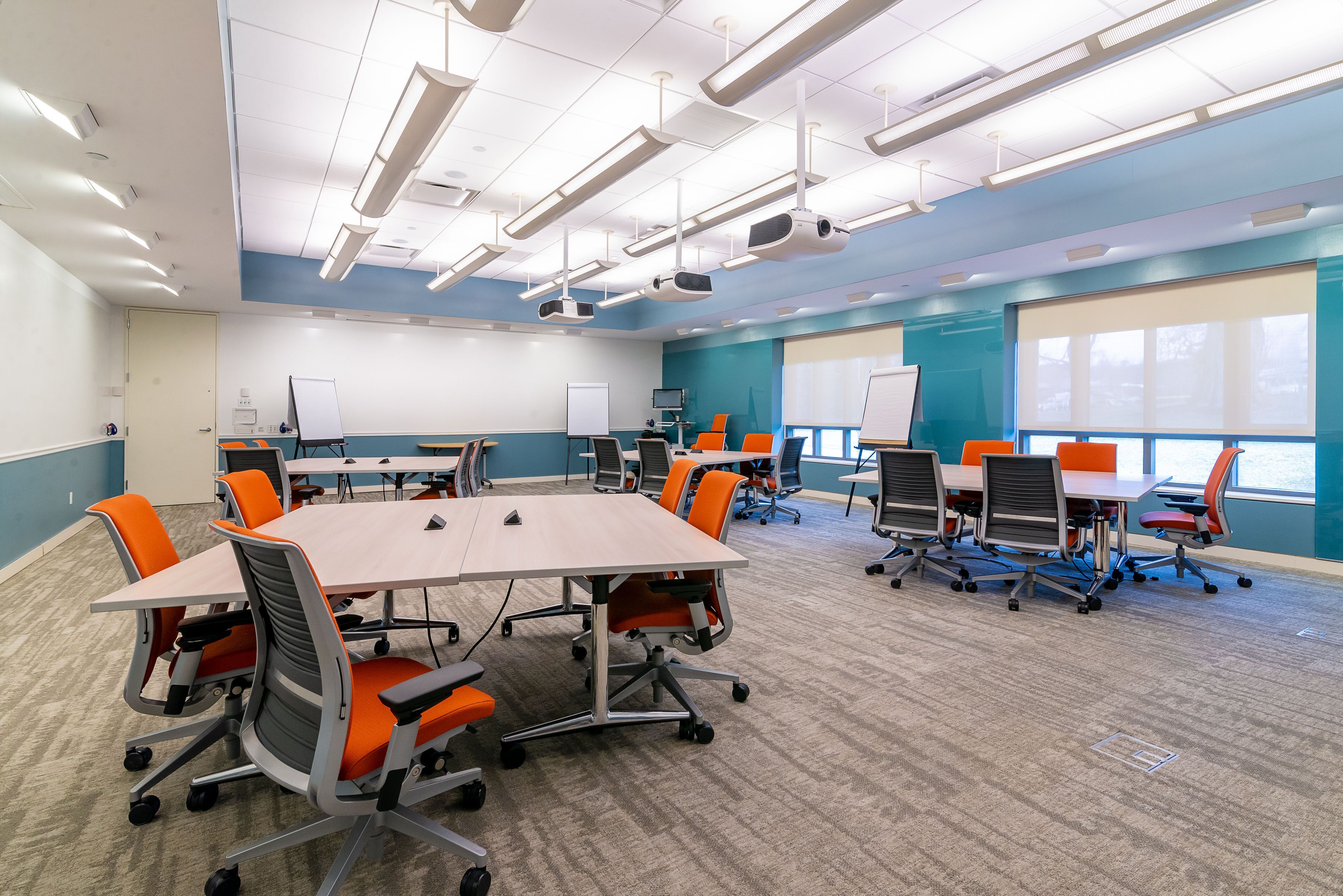 A conference room with a large table, multiple chairs, and a whiteboard.