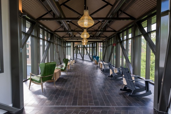 A sleek and modern glass-enclosed bridge at Windrose offers a bright space for relaxation, adorned with cozy seating and stylish lighting to enhance the serene atmosphere.