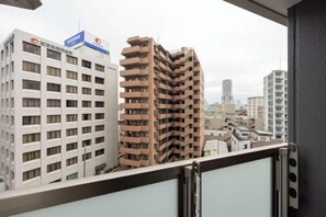 Udsigt til to højhuse fra en balkon.