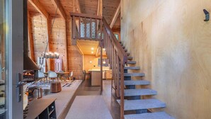 A wooden interior with a staircase, a dining area, and a kitchen. - Classic Chamberlands Outdoor Living & Soaking Tub! (Homewood)