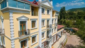 A multi-story building with balconies, large windows, and a courtyard. - Aykun Hotel (Almaty)