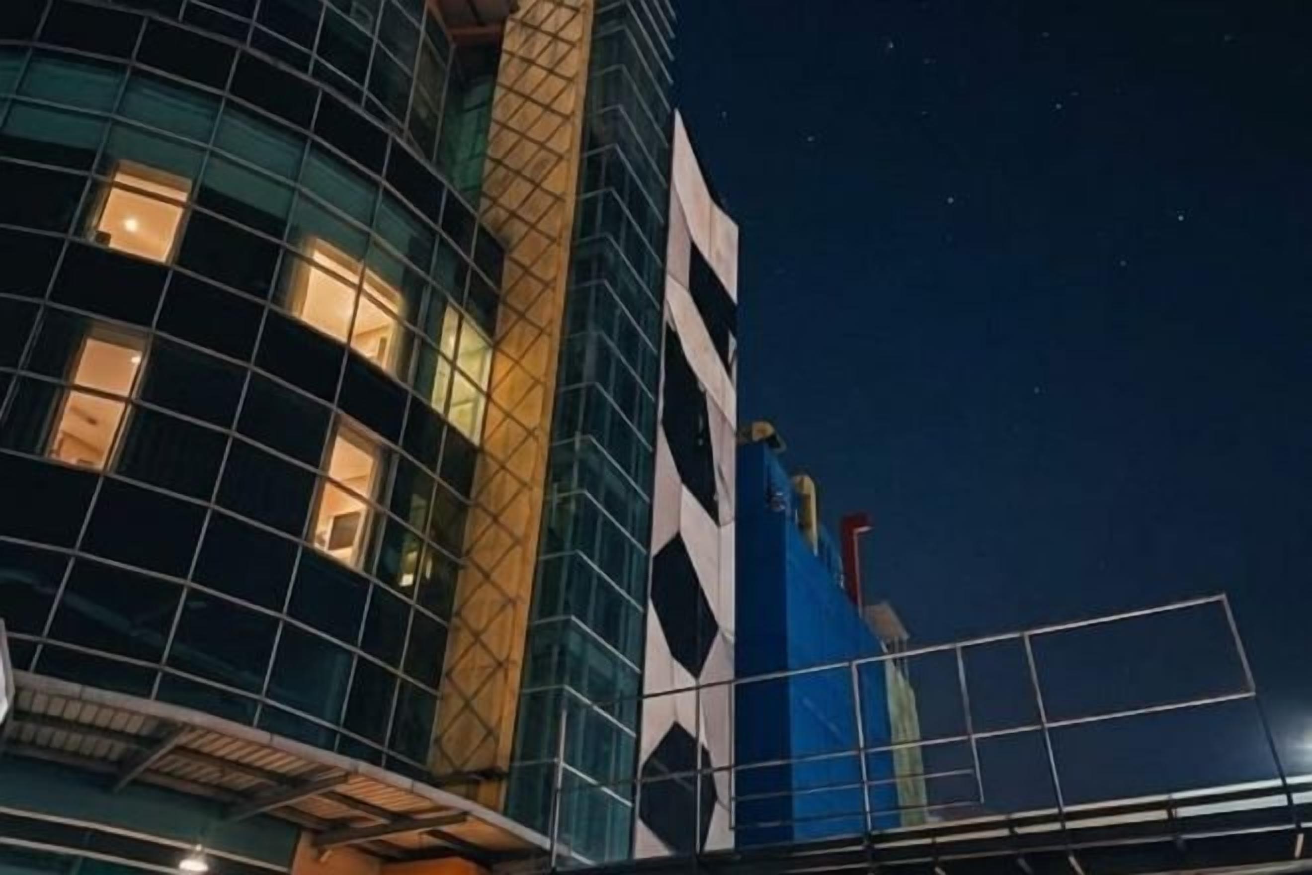 Un bâtiment moderne doté d’une façade en verre et d’une structure bleue, avec un design noir et blanc.