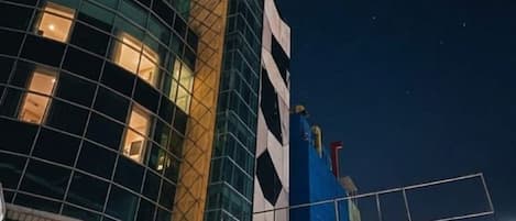 Un edificio moderno con fachada de vidrio y estructura azul con diseño blanco y negro.