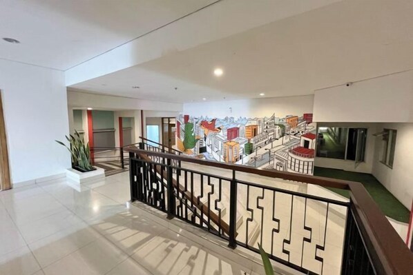 A spacious indoor area with a modern staircase, a large mural, and a clean, minimalist design.