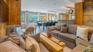 A cozy living room with a stone fireplace, a wooden coffee table, and a sofa. - LE REFUGE - VALLOIRE (VALLOIRE)