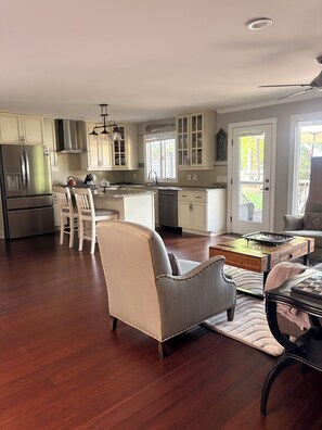 A spacious kitchen with modern appliances, a dining area with a chair, and a view through a door.