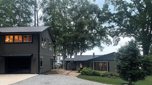 A modern two-story house with a gravel driveway and a well-maintained lawn.