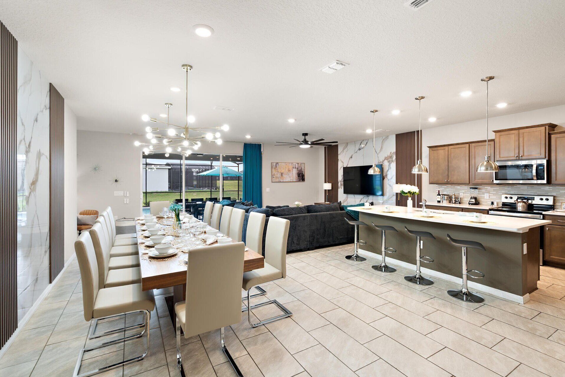 A modern kitchen with a dining area, featuring a large island, bar stools, and contemporary appliances.