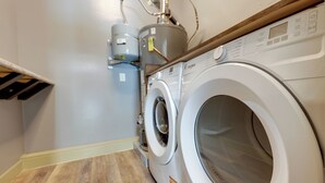 A laundry room with a front-loading washing machine and a stacked washer and dryer unit. - Close to Hospitals: Peaceful Birmingham Studio (Birmingham)