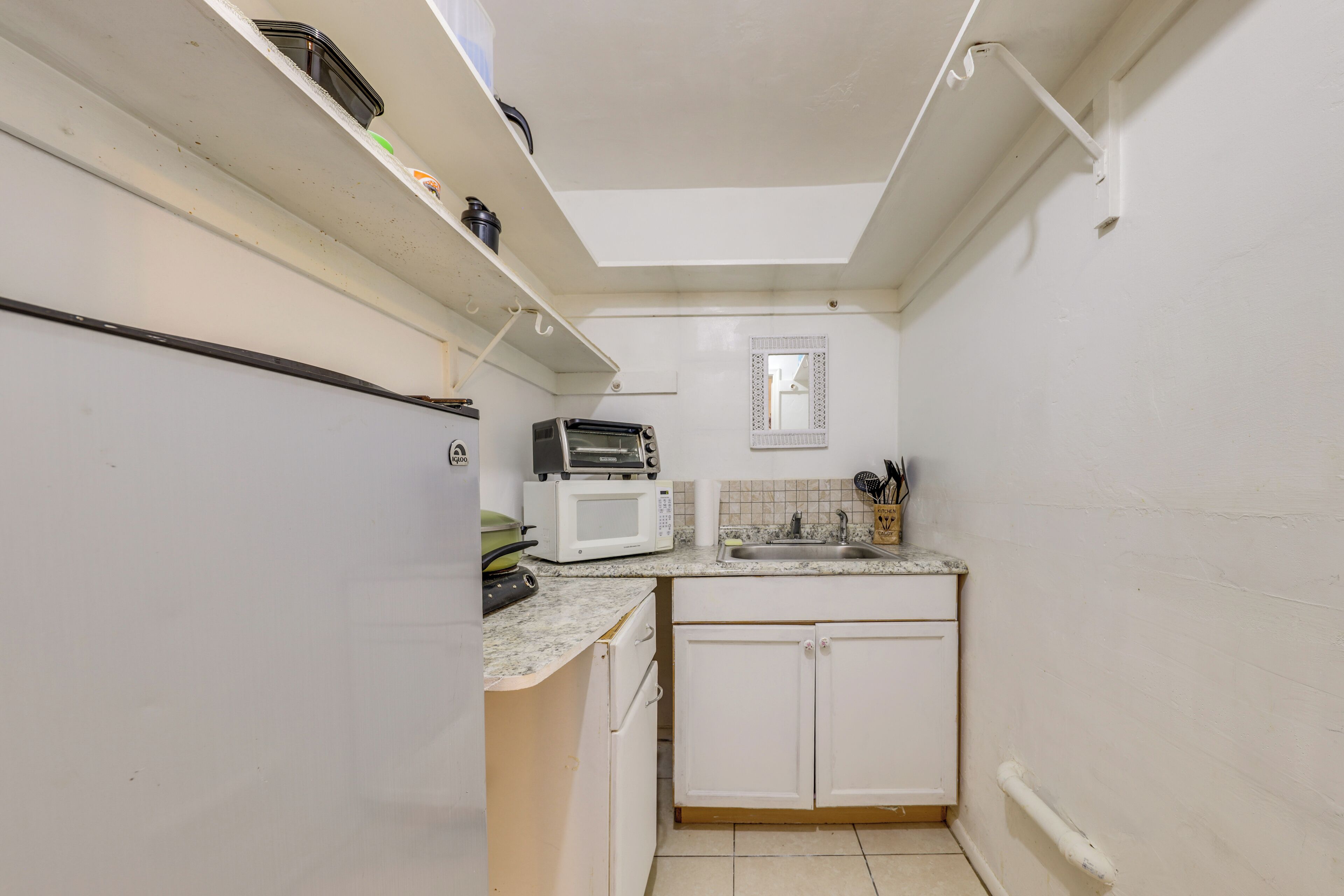 A compact kitchen with a microwave, toaster, and a small sink.