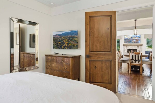 Une chambre à coucher avec un grand lit, une commode en bois et un tableau accroché au mur.