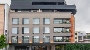 A multi-story hotel with a modern design, featuring balconies with plants, large windows, and a well-lit entrance. - Node Hotel (Manizales)