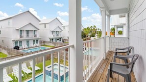 A residential property with a pool, white exterior, and a balcony with chairs. - Ellis Sands with LSV, Arcade, and Billiards (Miramar Beach)