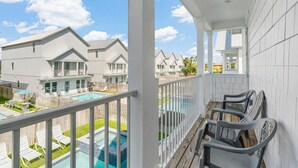 A balcony with a view of a swimming pool and neighboring houses. - Ellis Tide with LSV, Arcade, and Billiards (Miramar Beach)