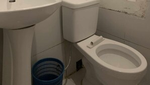 A small bathroom with a sink, toilet, and mirror. - WJV INN LILOAN (Liloan)