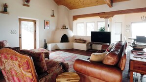 A cozy living room with a fireplace, leather sofas, and a television. - Salto Retreat, Valley Views, HotTub, Patio, Hiking (Arroyo Seco)