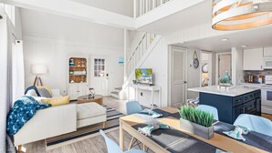 Un grand espace de vie comprenant un canapé, une table à manger et une cuisine.