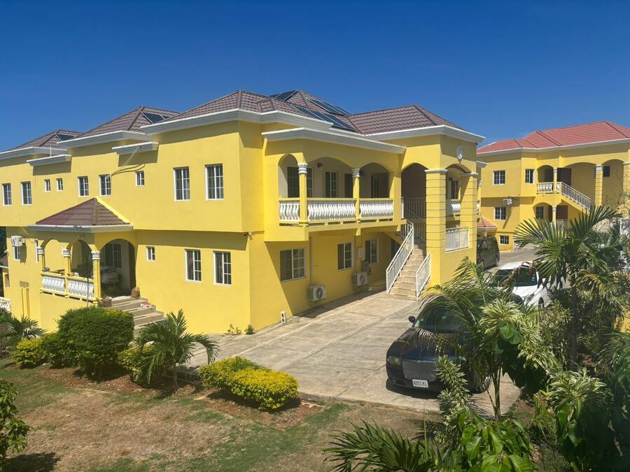 Un edificio grande y amarillo con varios balcones y una escalera central.