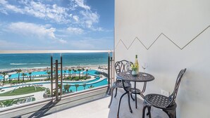 A balcony with a view of a swimming pool and beach.