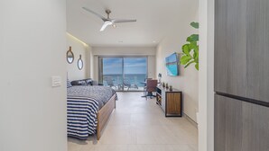 A modern bedroom with a bed, a desk, and a balcony with a view of the sea. - One 1407B Studio: Elegant Beachfront Getaway with Unmatched Views (Puerto Peñasco)