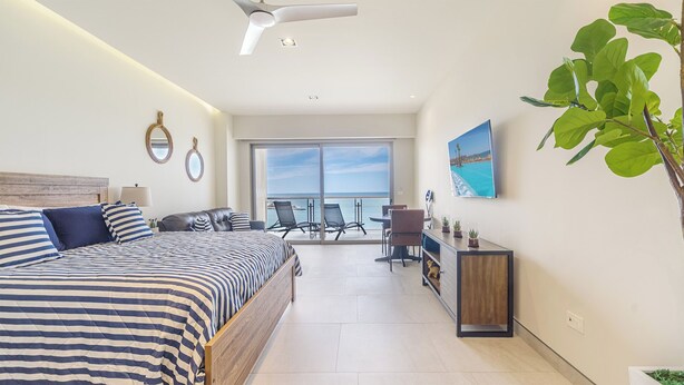 Une chambre d’hôtel moderne dotée d’un grand lit, d’un balcon avec vue et d’un coin repas.