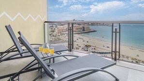A balcony with a view of a beach and cityscape. - One 1407B Studio: Elegant Beachfront Getaway with Unmatched Views (Puerto Peñasco)